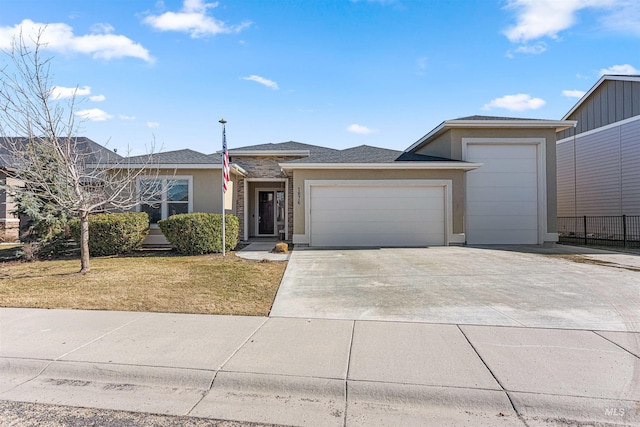 view of front facade with a garage, concrete driveway, fence, a front yard, and stucco siding