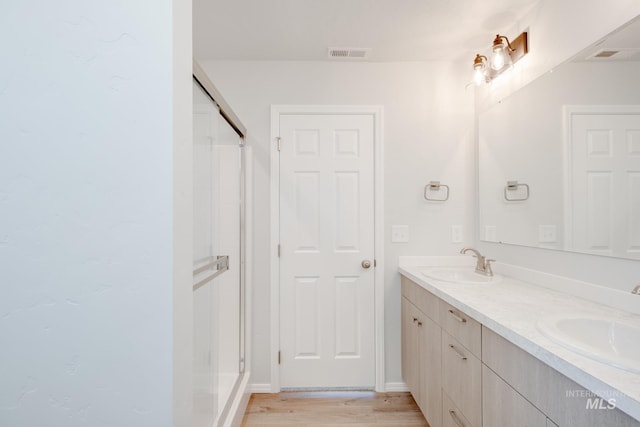 7331 E Marble Springs Dr, Nampa, ID 83687 - bathroom with a stall shower, double vanity, and wood finished floors