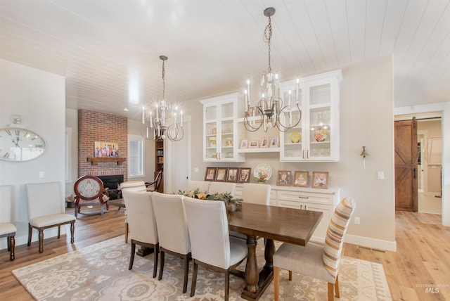 14050 Hidalgo Ranch Pl, Nampa, ID 83651 - dining area with a notable chandelier, light wood finished floors, a brick fireplace, baseboards, and wooden ceiling
