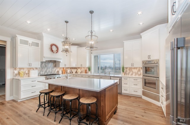 14050 Hidalgo Ranch Pl, Nampa, ID 83651 - kitchen with light countertops, appliances with stainless steel finishes, a breakfast bar area, and light wood-type flooring