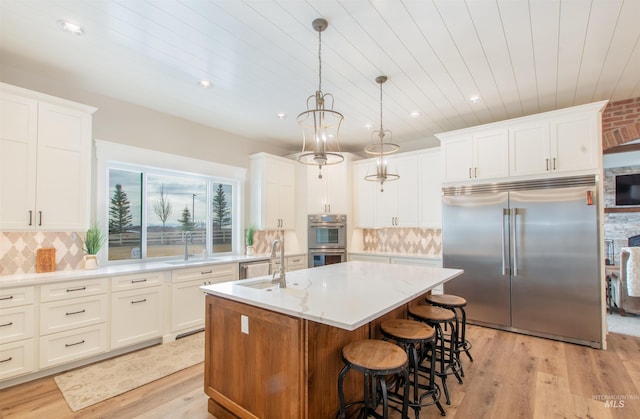 14050 Hidalgo Ranch Pl, Nampa, ID 83651 - kitchen with a center island with sink, a sink, wooden ceiling, light wood finished floors, and stainless steel appliances