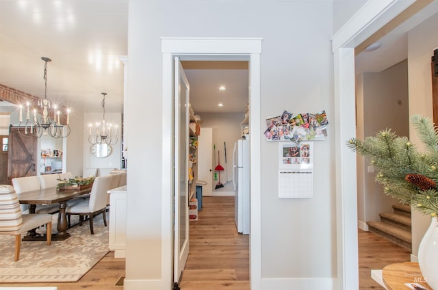 14050 Hidalgo Ranch Pl, Nampa, ID 83651 - hallway with stairs, a notable chandelier, and light wood finished floors
