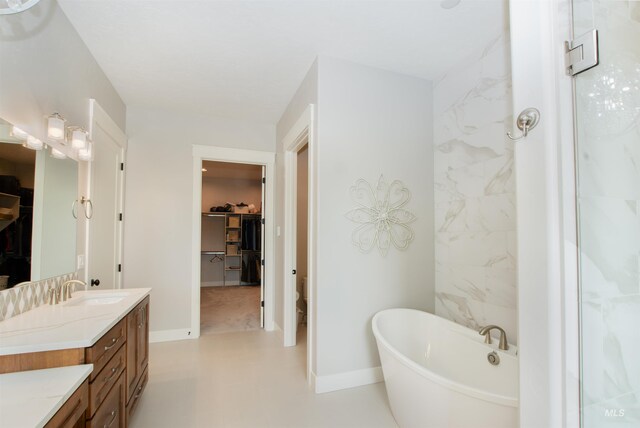 14050 Hidalgo Ranch Pl, Nampa, ID 83651 - bathroom featuring vanity, baseboards, a spacious closet, and a soaking tub