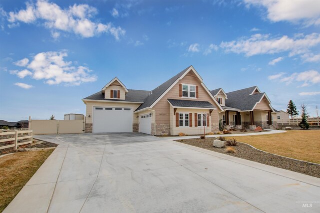 14050 Hidalgo Ranch Pl, Nampa, ID 83651 - craftsman house with a garage, fence, covered porch, stone siding, and concrete driveway