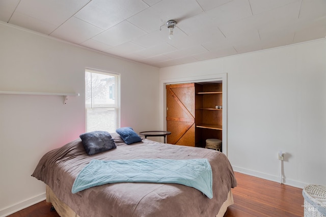 bedroom featuring baseboards and wood finished floors