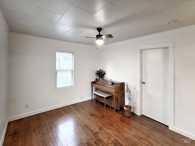 interior space with baseboards, hardwood / wood-style floors, and a ceiling fan