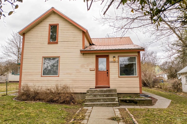 view of front of property featuring metal roof and a front yard