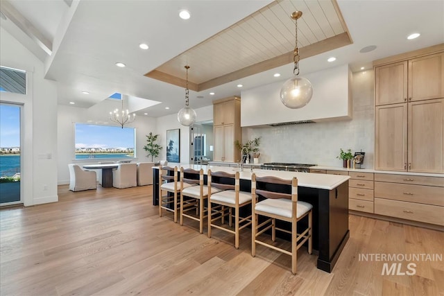 938 S Waning Ln, Eagle, ID 83616 - kitchen featuring light brown cabinetry, a tray ceiling, an island with sink, and recessed lighting