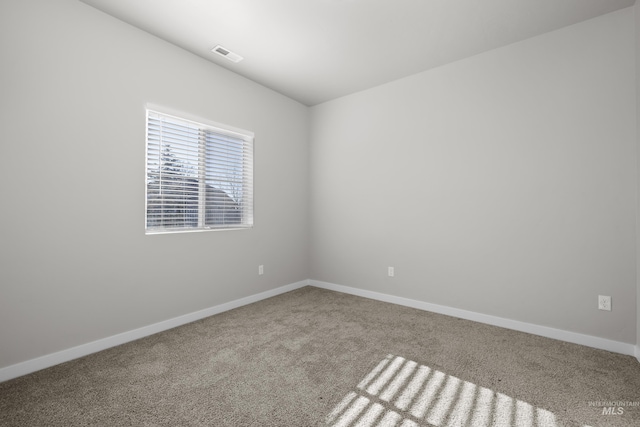 carpeted empty room with visible vents and baseboards