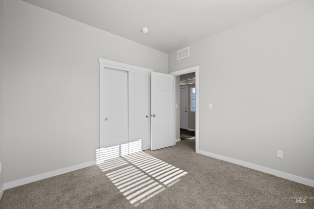 unfurnished bedroom featuring baseboards, visible vents, and carpet flooring