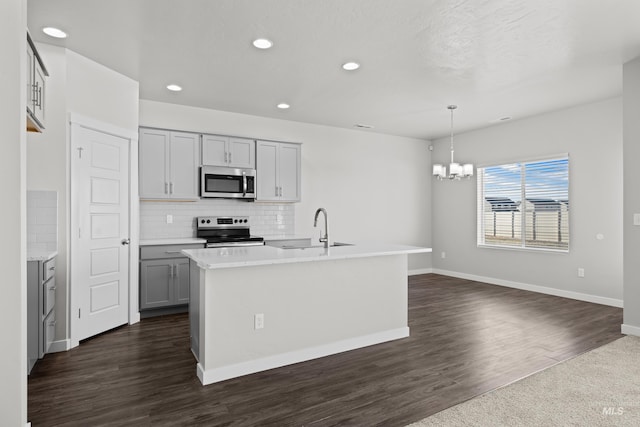 kitchen featuring gray cabinets, light countertops, backsplash, appliances with stainless steel finishes, and a sink