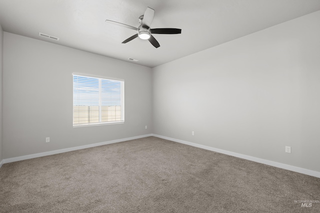 spare room featuring ceiling fan, carpet floors, visible vents, and baseboards