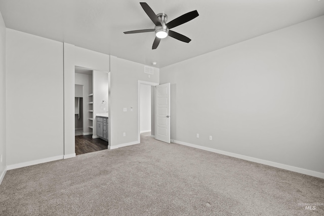 unfurnished bedroom with baseboards, visible vents, ensuite bath, ceiling fan, and carpet floors