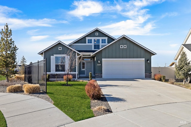 view of front of property featuring concrete driveway, an attached garage, fence, a front lawn, and board and batten siding