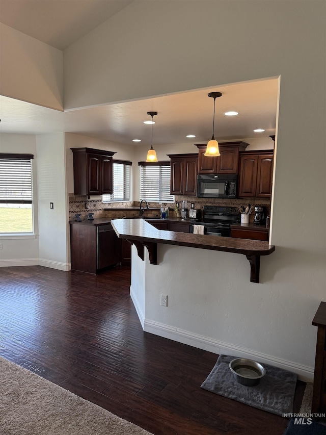 2486 E 3745, Twin Falls, ID 83301 - kitchen with dark countertops, dark brown cabinetry, black appliances, and a kitchen bar