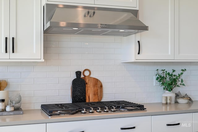 kitchen with white cabinetry, decorative backsplash, exhaust hood, and stainless steel gas cooktop