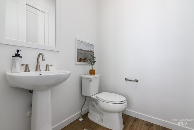 bathroom with hardwood / wood-style floors, sink, and toilet