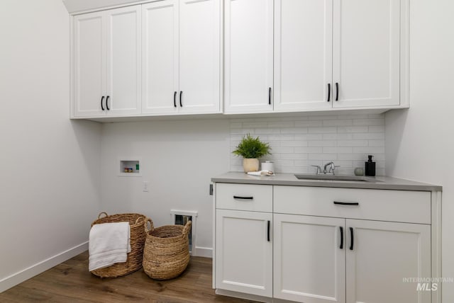 laundry room featuring sink, hookup for a washing machine, dark hardwood / wood-style floors, and cabinets