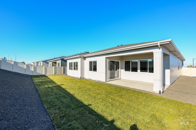 back of house featuring a patio and a lawn