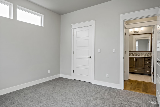 unfurnished bedroom featuring sink and light colored carpet