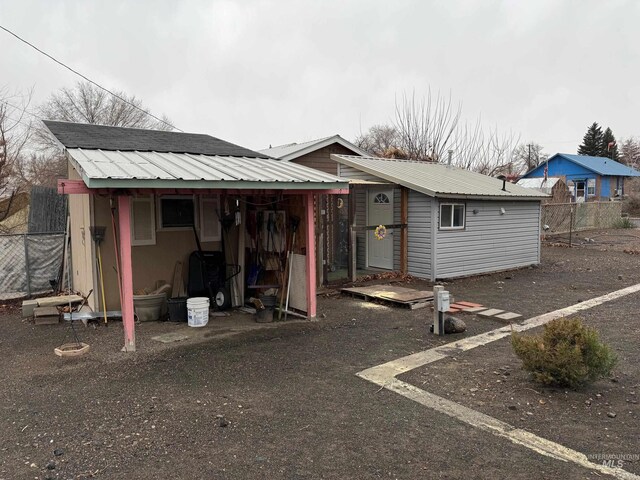 rear view of property featuring a storage shed