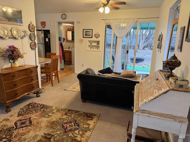 carpeted living room with ceiling fan