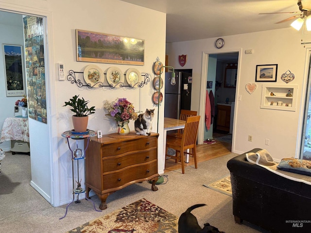 interior space with ceiling fan and light colored carpet