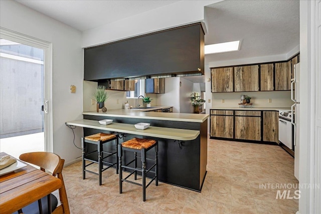 300 Morrison Unit 643, Twin Falls, ID 83301 - kitchen featuring plenty of natural light, brown cabinets, a peninsula, and light countertops
