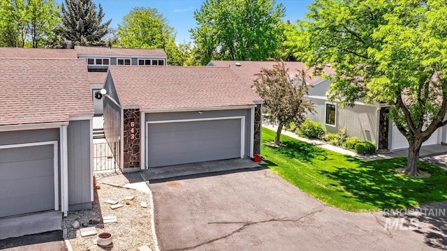 300 Morrison Unit 643, Twin Falls, ID 83301 - view of front of house with a shingled roof, driveway, a front lawn, a garage, and stone siding