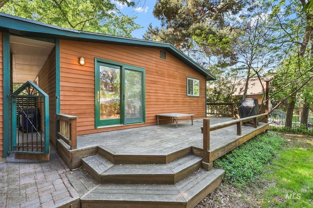 rear view of property featuring a wooden deck and fence