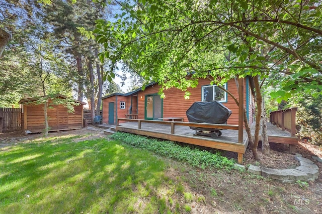 rear view of house with a wooden deck, a storage shed, and an outdoor structure