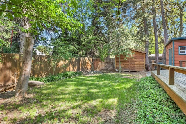 view of yard featuring a storage shed, an outbuilding, and a deck