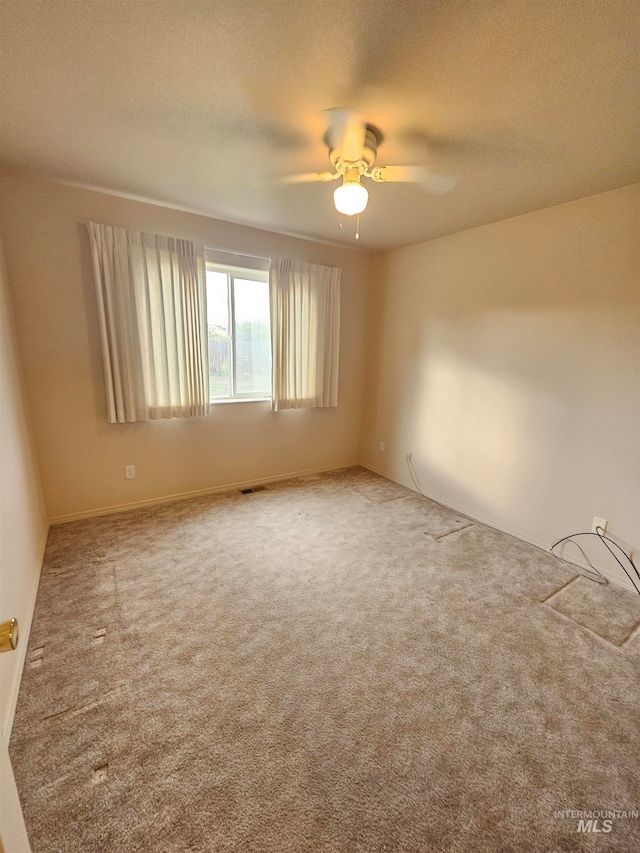 carpeted spare room featuring a textured ceiling and ceiling fan