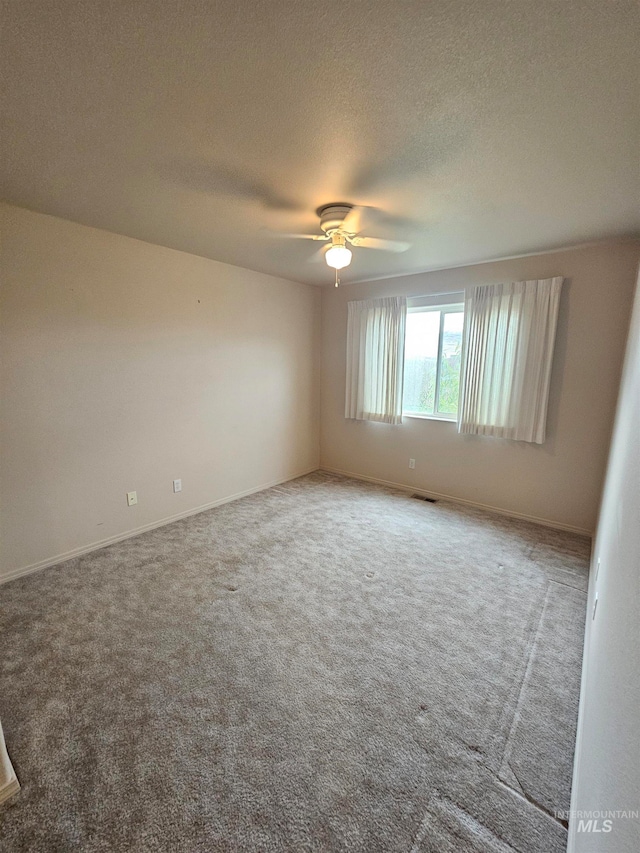 spare room featuring a textured ceiling, carpet floors, and ceiling fan