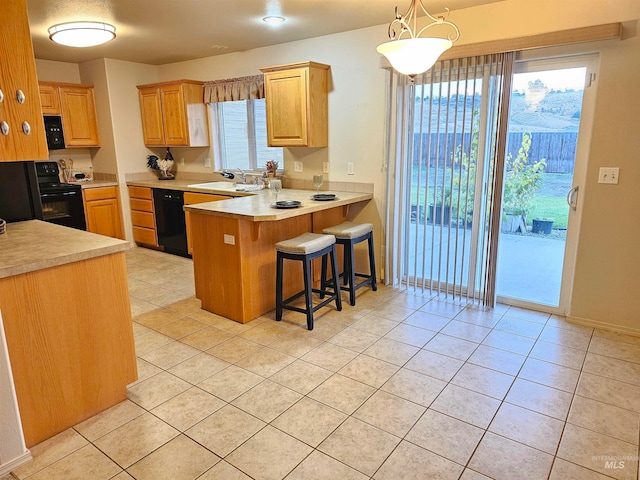 kitchen with pendant lighting, a breakfast bar, black appliances, sink, and kitchen peninsula