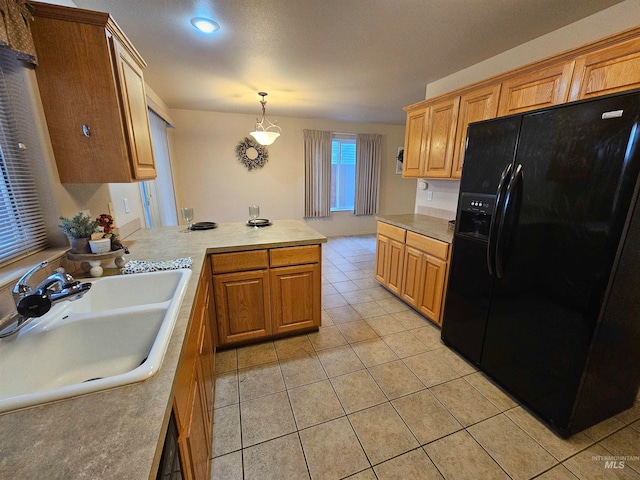 kitchen featuring sink, kitchen peninsula, decorative light fixtures, black fridge with ice dispenser, and light tile patterned floors