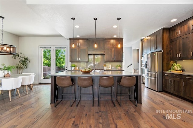 5085 S Taboo Pl, Boise, ID 83716 - kitchen featuring stainless steel fridge with ice dispenser, light countertops, a kitchen breakfast bar, dark wood-style flooring, and recessed lighting