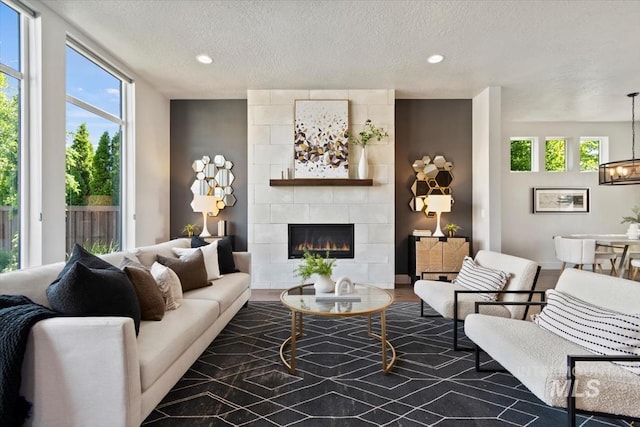 5085 S Taboo Pl, Boise, ID 83716 - living area with a tiled fireplace, plenty of natural light, a textured ceiling, recessed lighting, and a chandelier