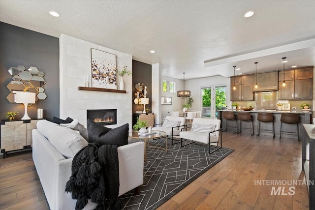 5085 S Taboo Pl, Boise, ID 83716 - living area featuring hardwood / wood-style floors, a tile fireplace, recessed lighting, and a textured ceiling