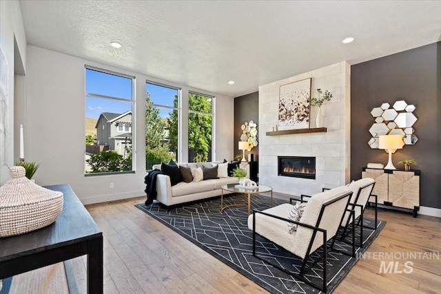 5085 S Taboo Pl, Boise, ID 83716 - living room with wood-type flooring, a tile fireplace, baseboards, and recessed lighting