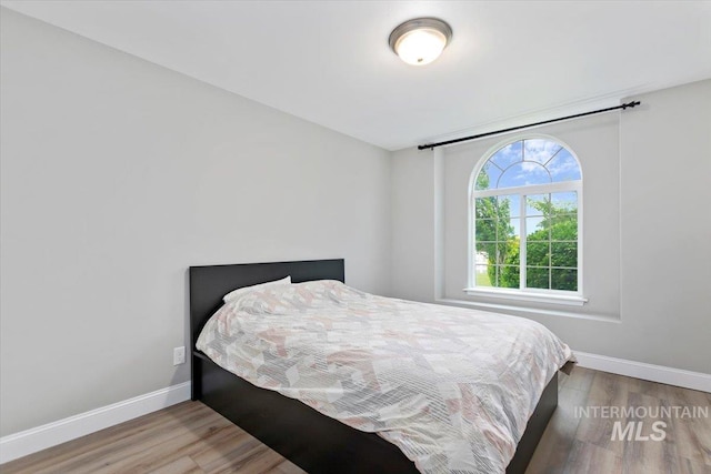 bedroom featuring baseboards and wood finished floors