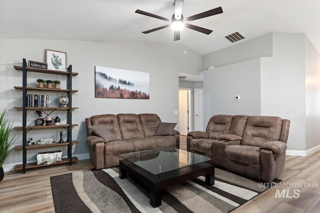 living room with lofted ceiling, visible vents, light wood-style floors, a ceiling fan, and baseboards