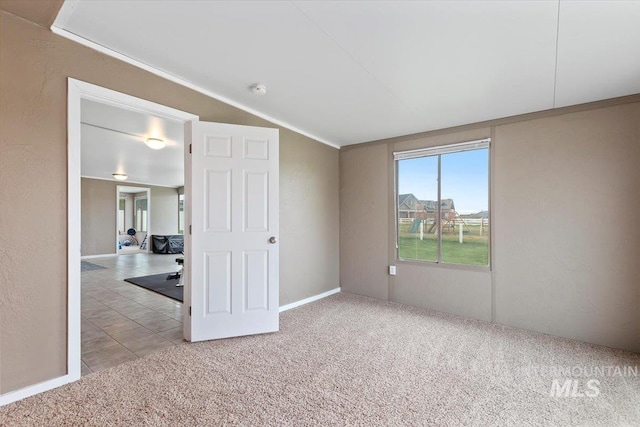 spare room featuring lofted ceiling, light colored carpet, and crown molding