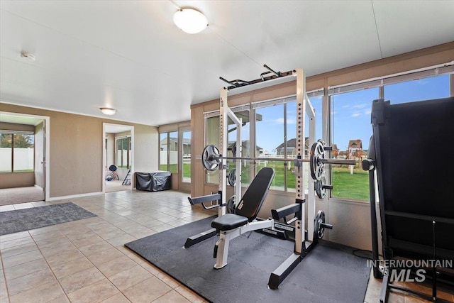 exercise room with plenty of natural light and tile patterned floors