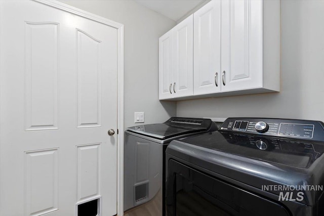 laundry area featuring separate washer and dryer and cabinet space