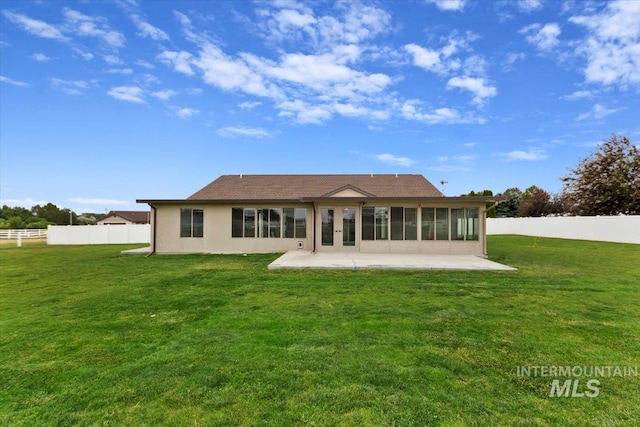 rear view of property with fence private yard, a sunroom, a lawn, stucco siding, and a patio area