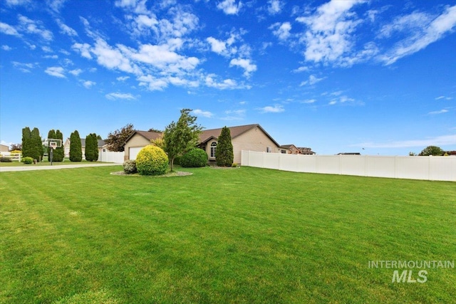 view of yard with a garage and fence