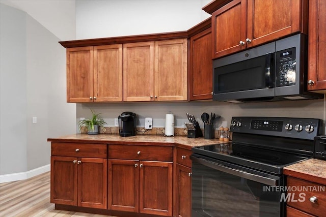 kitchen with light wood-style flooring, baseboards, black electric range, light countertops, and brown cabinets