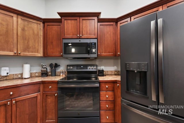 kitchen with light countertops, appliances with stainless steel finishes, and brown cabinetry