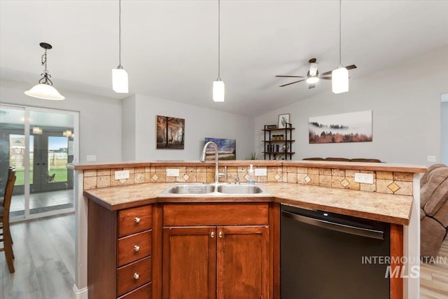 kitchen with dishwasher, brown cabinets, open floor plan, light countertops, and a sink